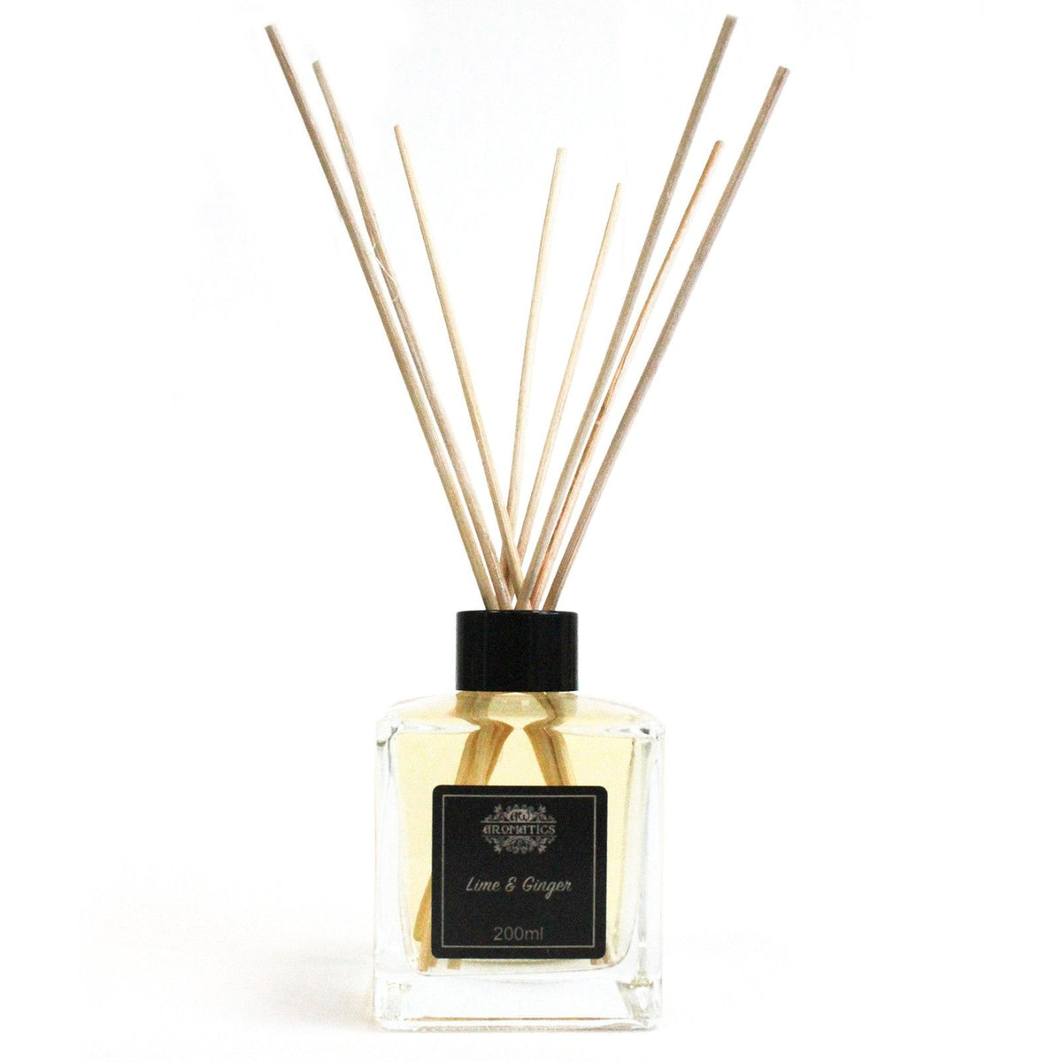 Difusor de aceites aromáticos de lima y jengibre en frasco de vidrio cuadrado con varillas de madera sobre fondo blanco.