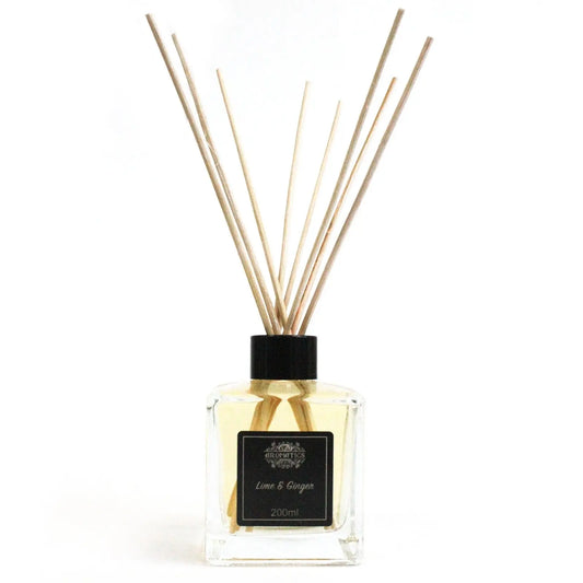 Difusor de aceites aromáticos de lima y jengibre en frasco de vidrio cuadrado con varillas de madera sobre fondo blanco.