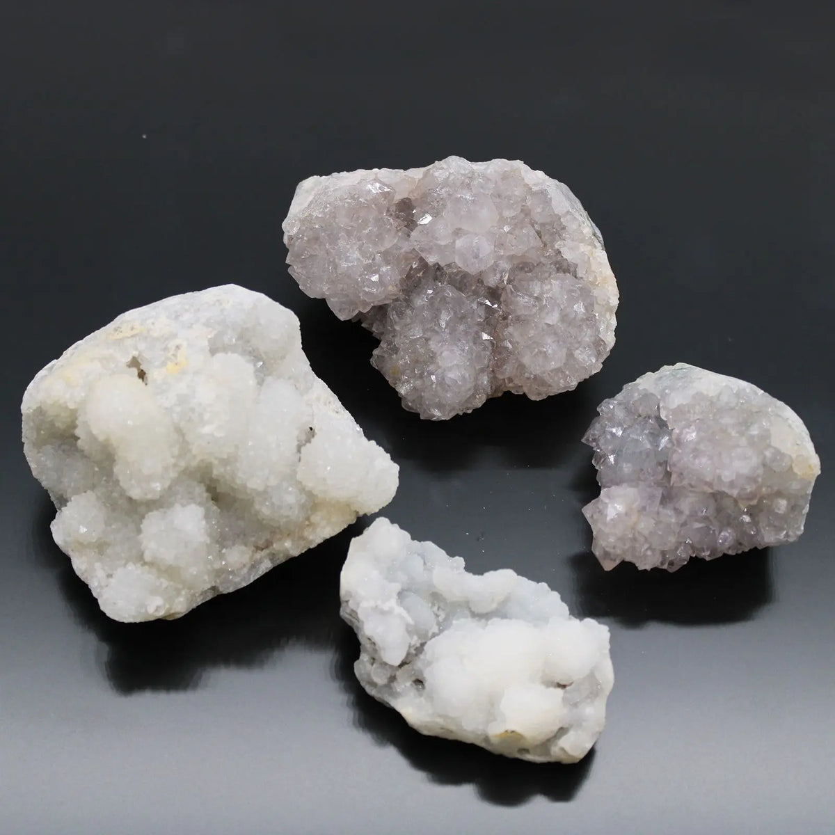 Piedras de cristal gris y púrpura, variedades de cuarzo, decorativas y brillantes, fondo negro.