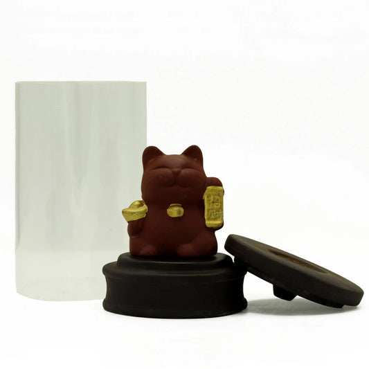 Quemador de incienso de cerámica marrón con figura de gato afortunado y tubo de cristal sobre fondo blanco