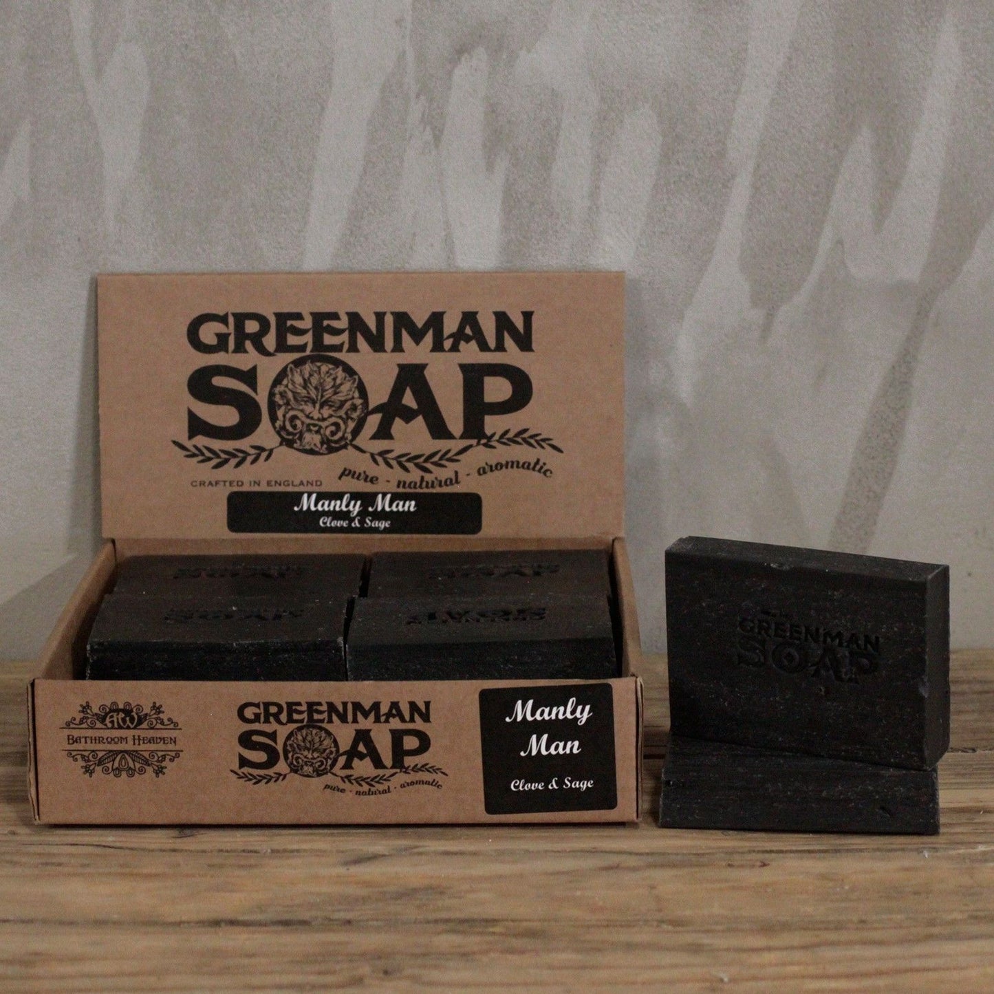 Jabón artesanal oscuro para hombre en caja de cartón reciclado estilo rústico sobre superficie de madera natural