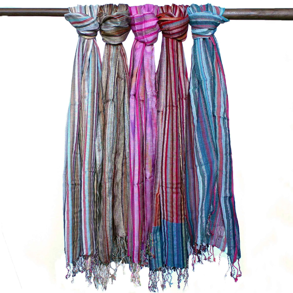 Cinco bufandas largas de tela ligera con rayas verticales multicolores y flecos en los extremos, colgadas de una vara.