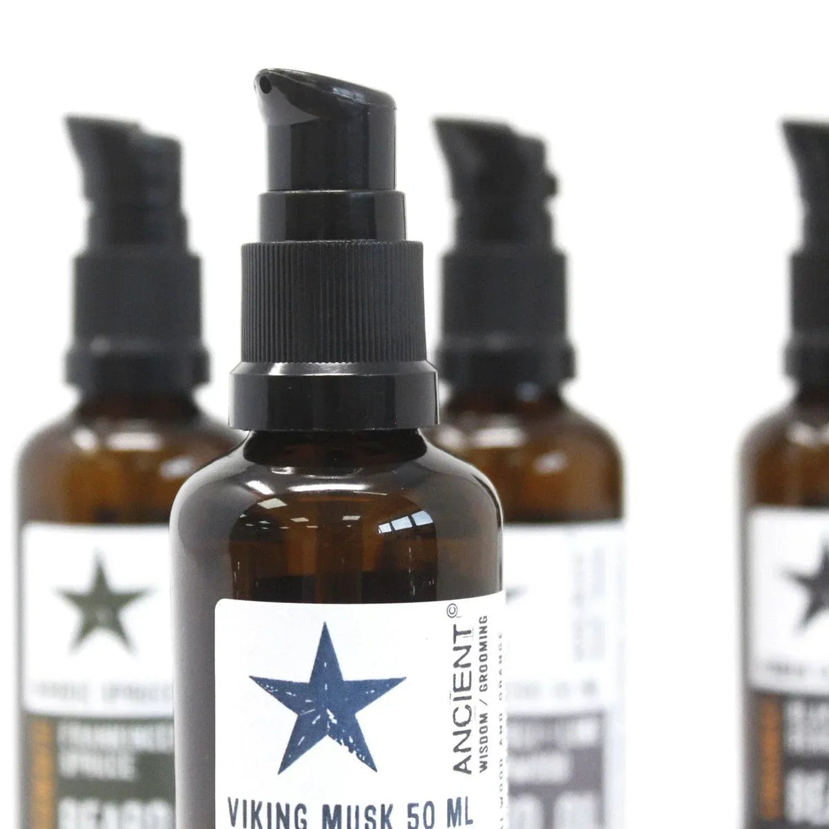 Frascos de vidrio ámbar de 50ml con dosificador negro y etiqueta blanca con estrella, aceite para barba Ancient Wisdom.