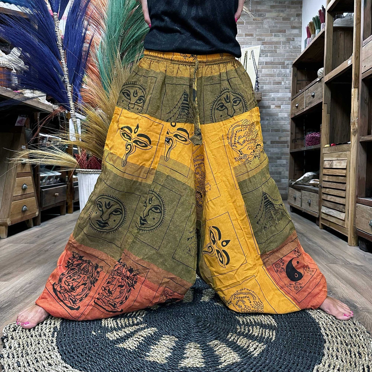Pantalones tipo Aladdin naranjas y verdes con estampado hindú, cintura elástica y corte holgado para yoga o festivales.