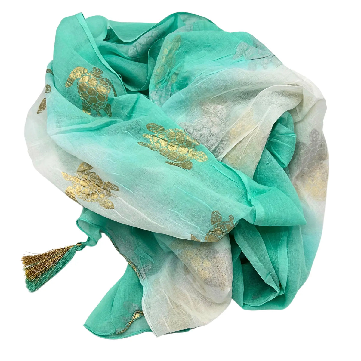 Pareo ligero de tela degradada en blanco y turquesa con estampado de tortugas doradas y fleco en la esquina.