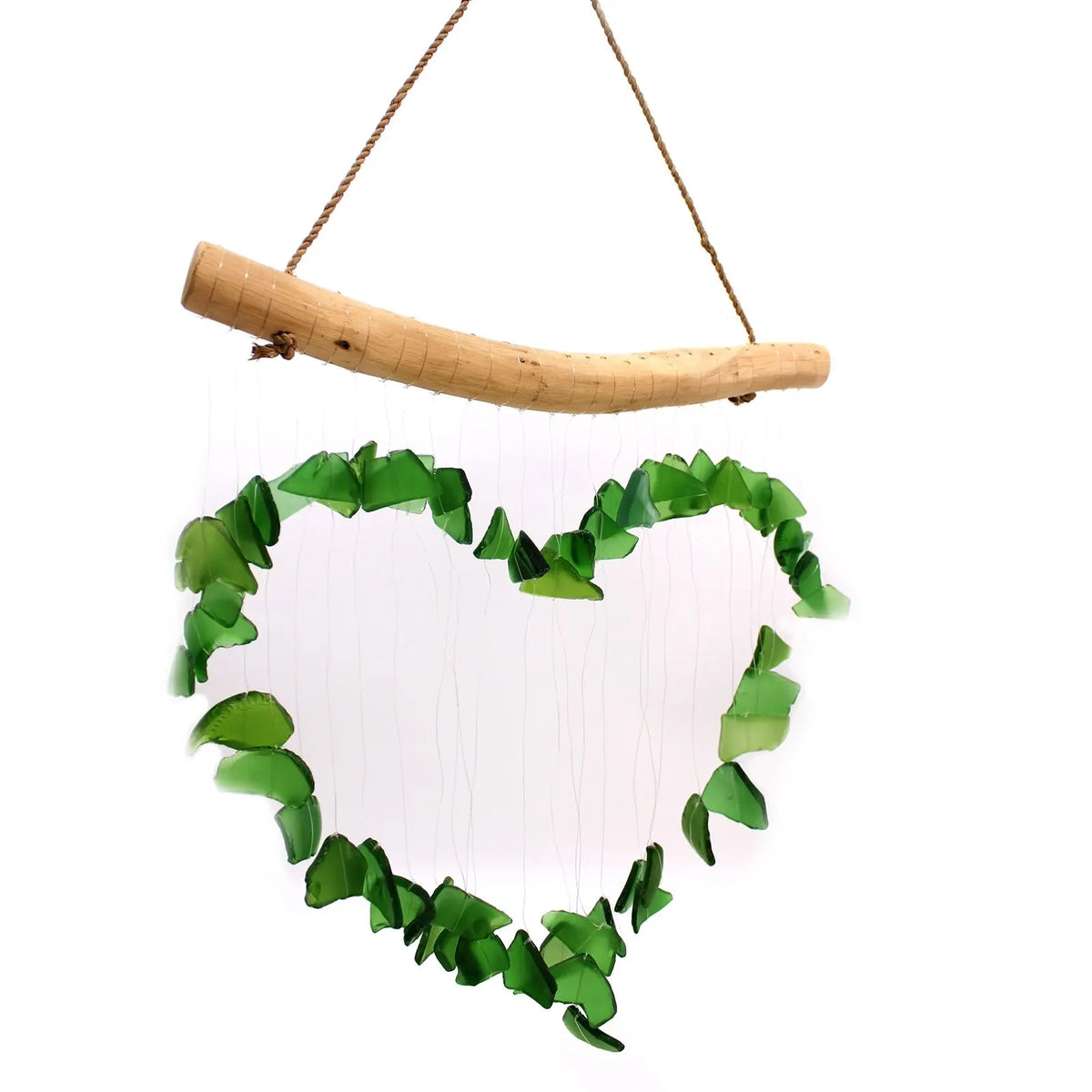 Carillón con forma de corazón hecho de piezas de vidrio reciclado verde colgando de una rama de madera natural.