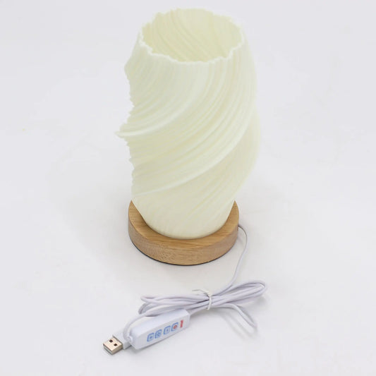 Lámpara de mesa blanca con pantalla texturizada en espiral sobre base circular de madera y cable con conexión USB.