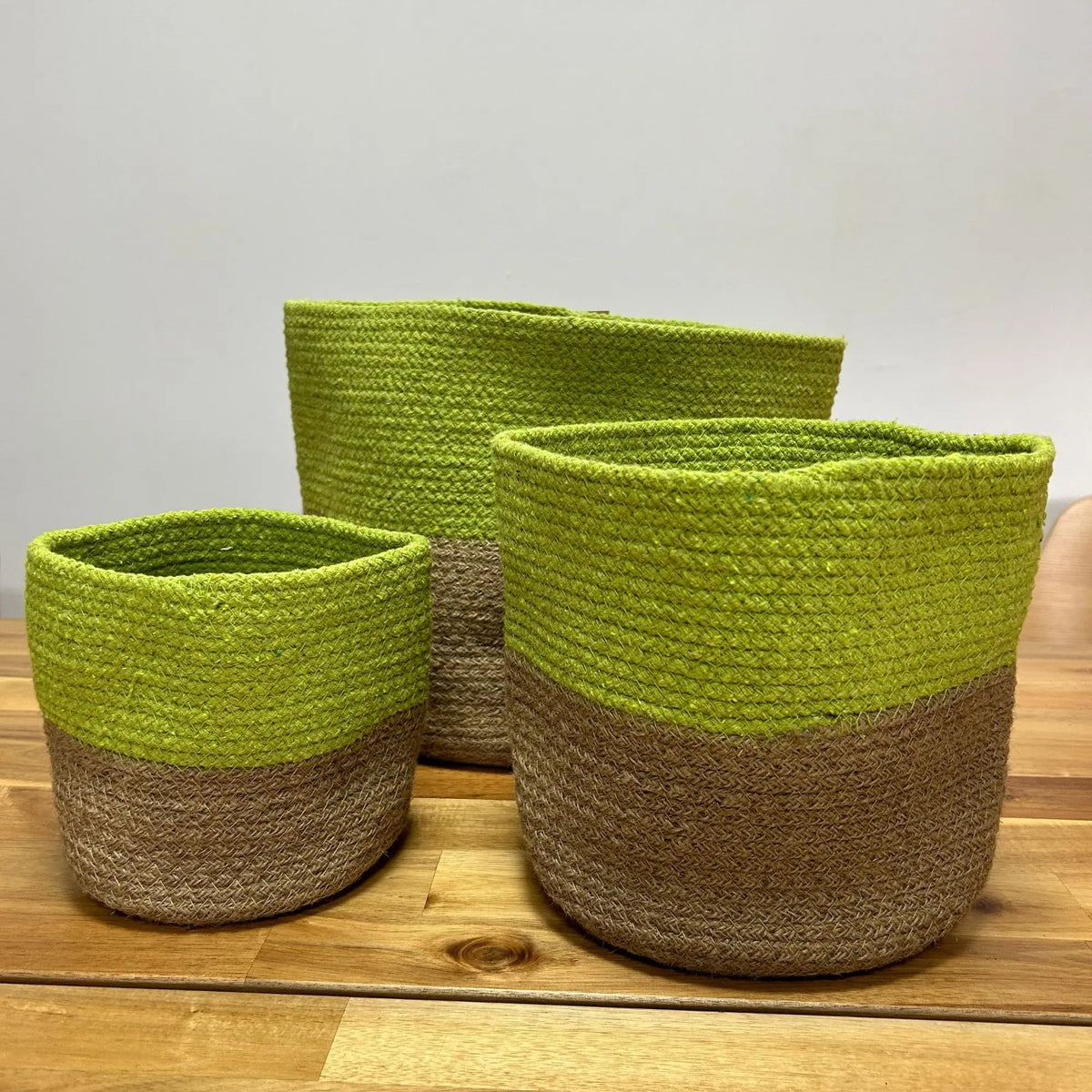 Cestos de yute trenzado en verde fosforescente y marrón, ideales para decoración y organización del hogar.