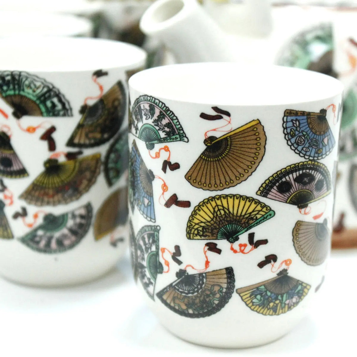 Tazas de cerámica blanca con estampado colorido de abanicos chinos tradicionales para té.