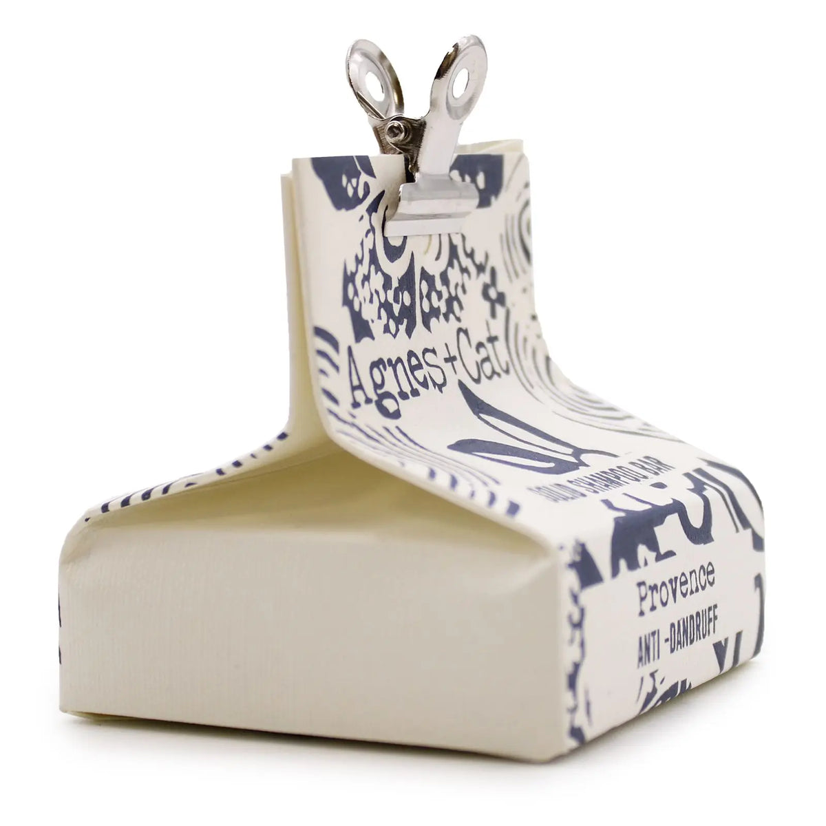 Champú sólido Provence Agnes + Cat en papel crema con estampado azul, cerrado con una pinza metálica.