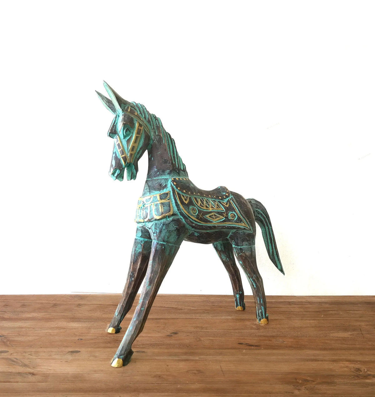 Caballo decorativo de madera en tonos verde y dorado, estilo artesanal, ideal para decoración rústica.