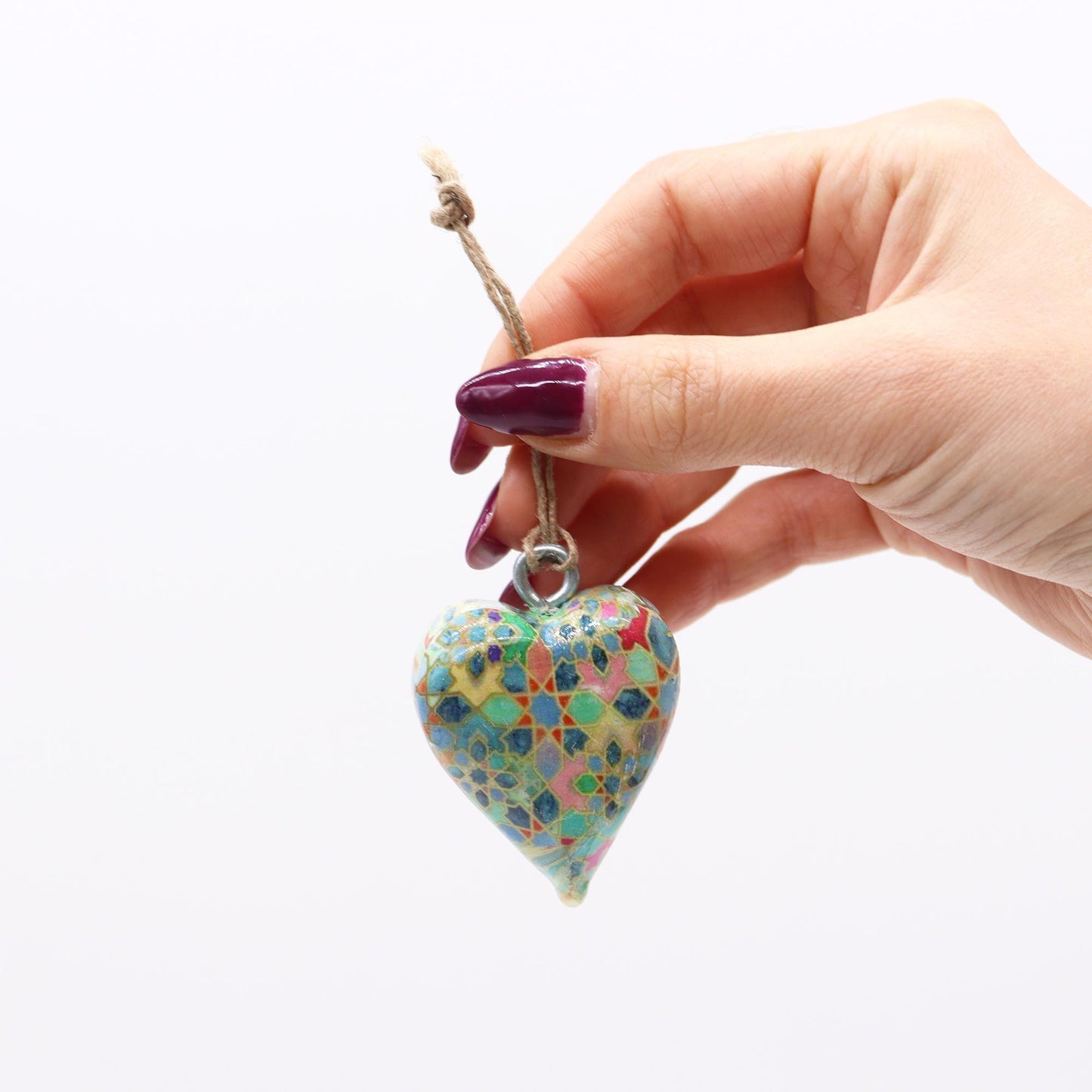 Corazón decorativo de cerámica azul y multicolor con patrón geométrico, colgante en cordón de yute.