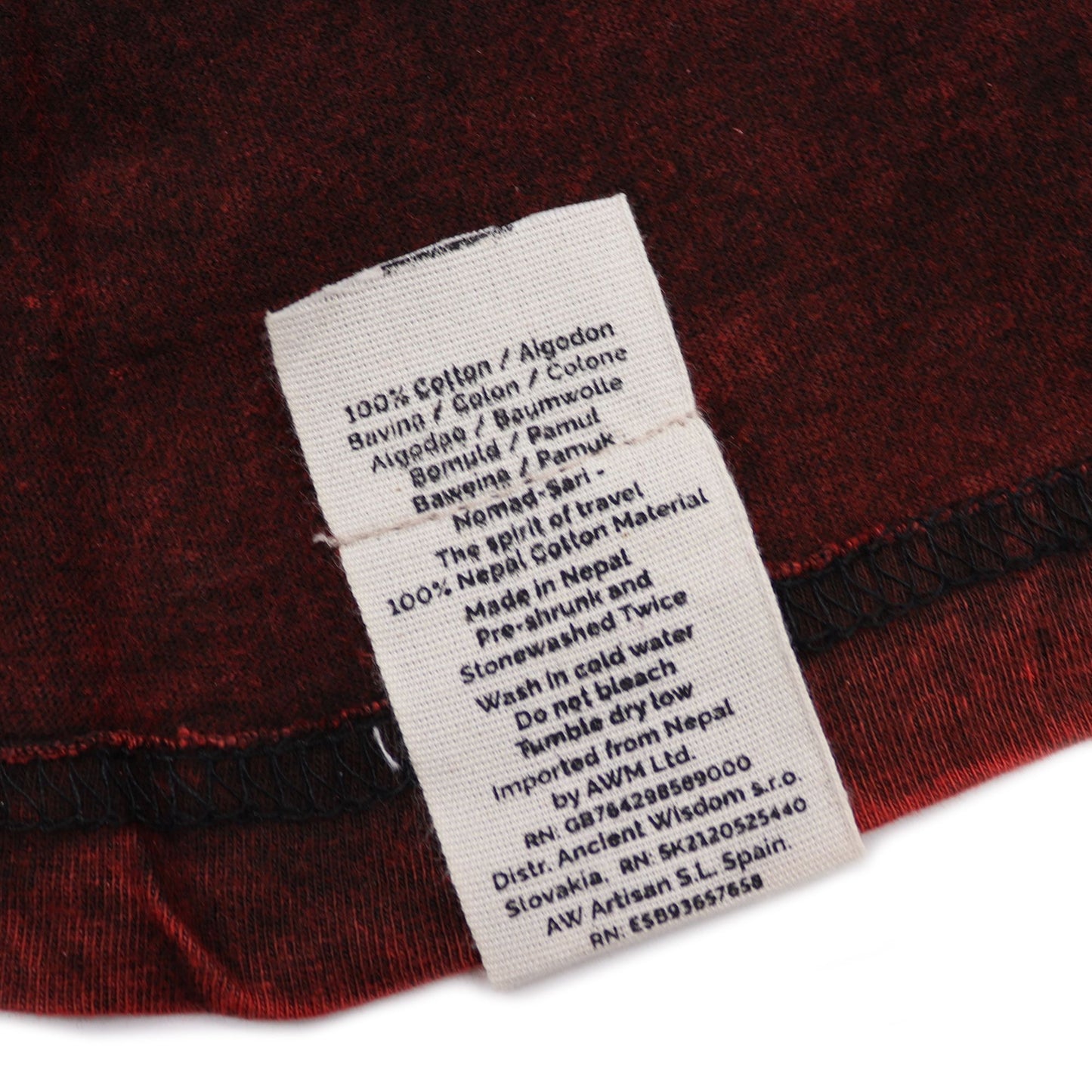 Camiseta burdeos de algodón, estilo casual, importada de Nepal, con etiqueta de cuidado y detalles de materiales.