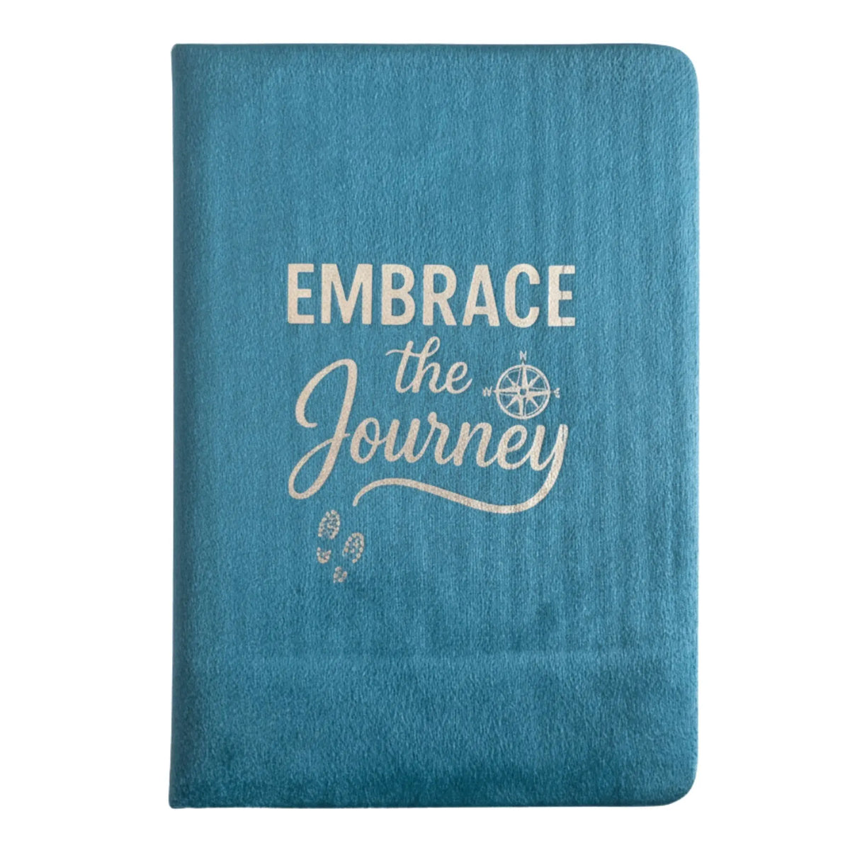 Cuaderno de terciopelo azul claro con la frase "Embrace the Journey" y un icono de brújula grabados en la portada.