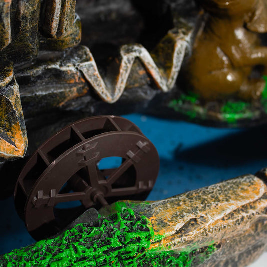 Rueda de agua marrón con detalles en piedras grises y verdes, ideal para decoración de fuentes o jardines.