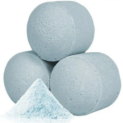 Tres bombitas de baño circulares de color azul claro junto a un pequeño montón de polvo de talco del mismo tono
