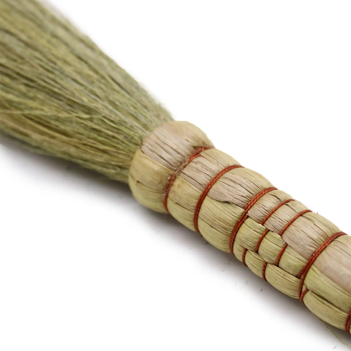 Escobilla de palma verde, con mango de cuerda natural y detalles rojos, ideal para limpieza ecológica.