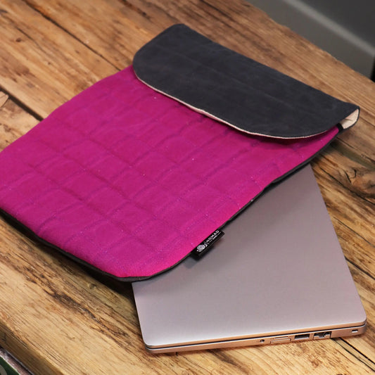 Funda para laptop de algodón rosa y gris con textura acolchada, ideal para proteger dispositivos electrónicos.