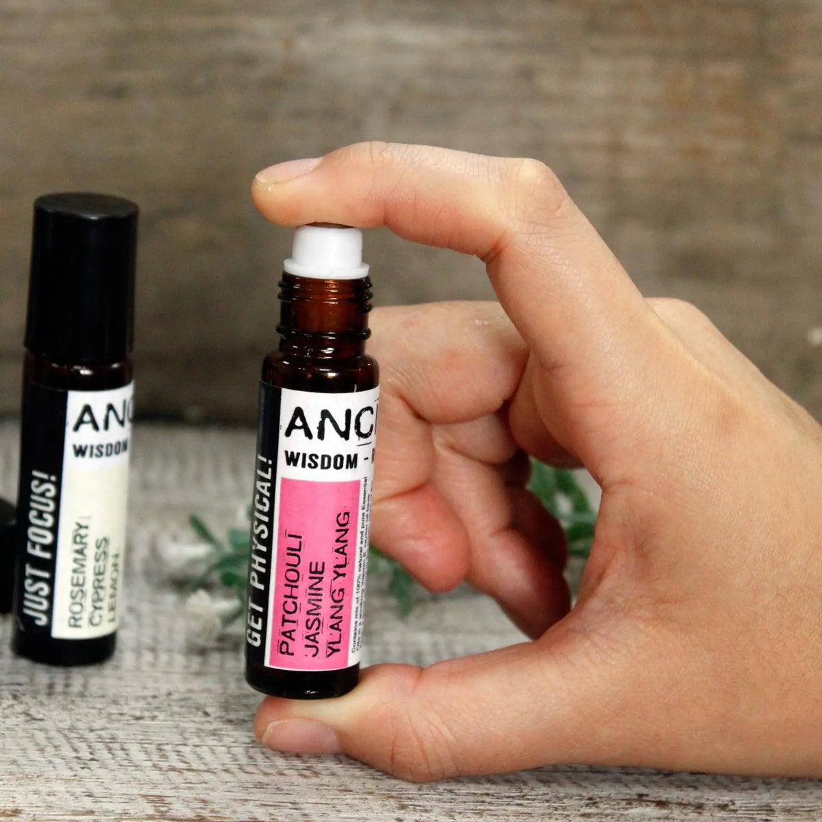 Aceite esencial de patchouli y jazmín en frasco ámbar con tapa blanca, estilo moderno y aromaterapia.