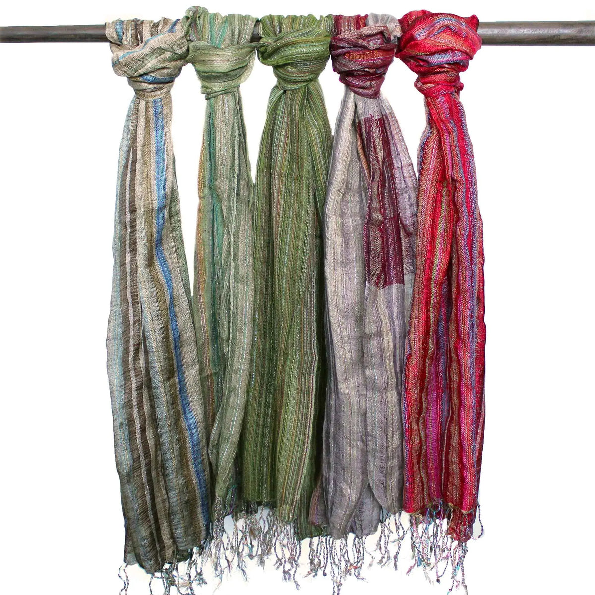 Cinco bufandas bohemias de rayas multicolores y textura artesanal con flecos, colgadas de un soporte metálico.