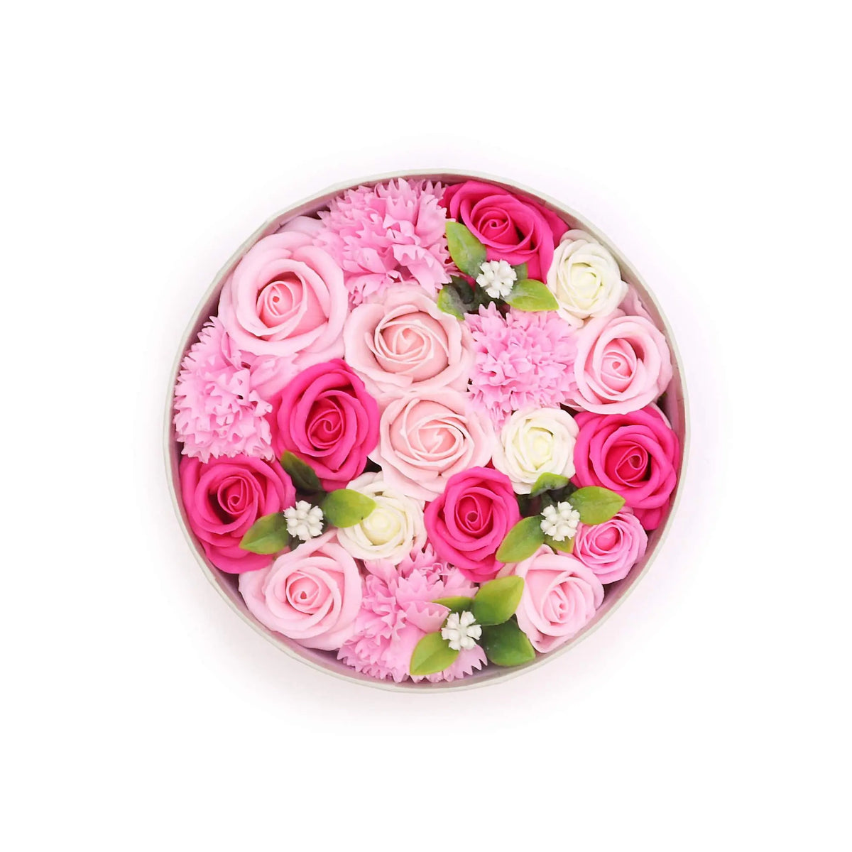 Caja redonda con rosas y flores de jabón en tonos rosa, blanco y fucsia, con hojas verdes decorativas.
