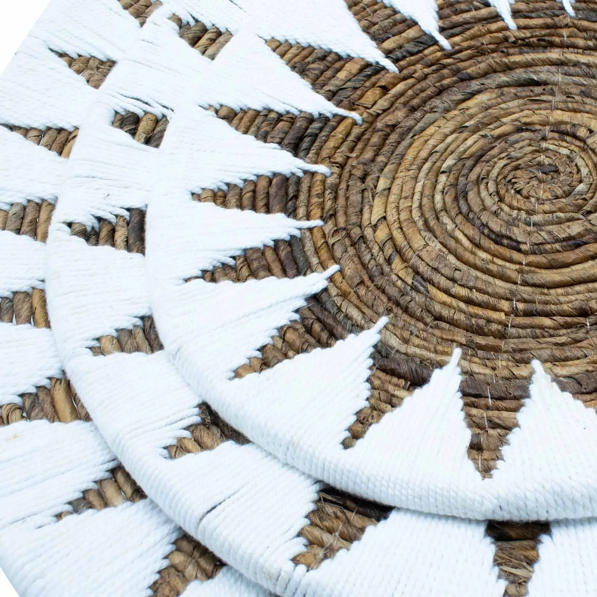 Juego de 3 posavasos redondos de mimbre natural con diseño blanco en forma de sol.