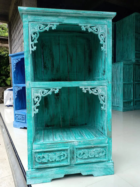 Mueble de baño de madera turquesa con estantes abiertos, detalles tallados en estilo rústico y acabado decapado.