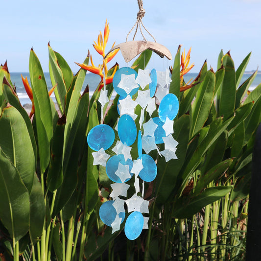 Carillón de coco con figuras de concha capiz en forma de estrellas blancas y círculos azules, estilo artesanal.
