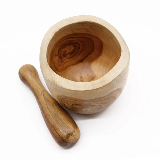 Mortero y maja de madera de teca con veteado natural, forma redondeada y acabado artesanal, sobre fondo blanco.