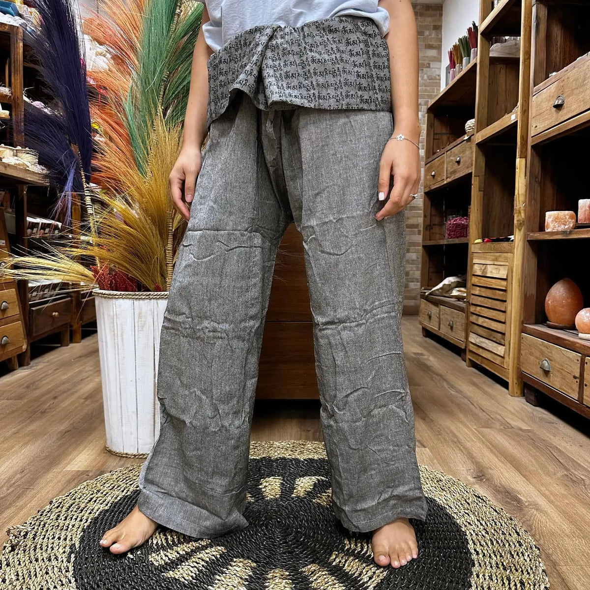 Pantalón de pescador tailandés gris, corte ancho, con cintura estampada de mantras y tejido de algodón rústico.