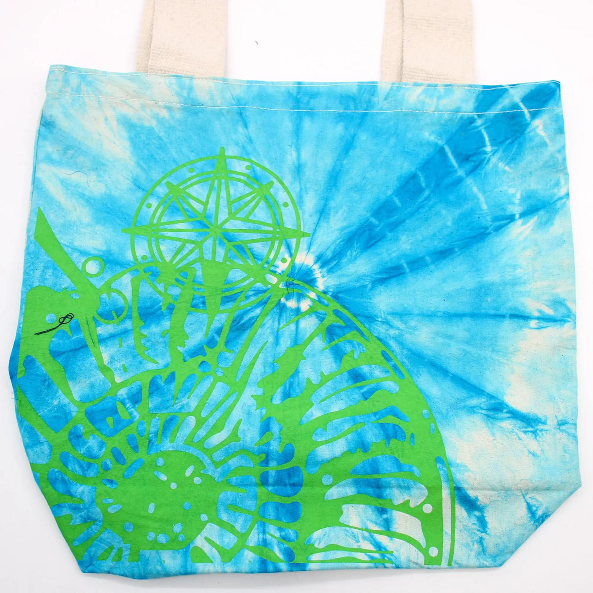 Bolsa de algodón tie-dye azul con estampado verde de concha marina y brújula. Asas de tela natural.