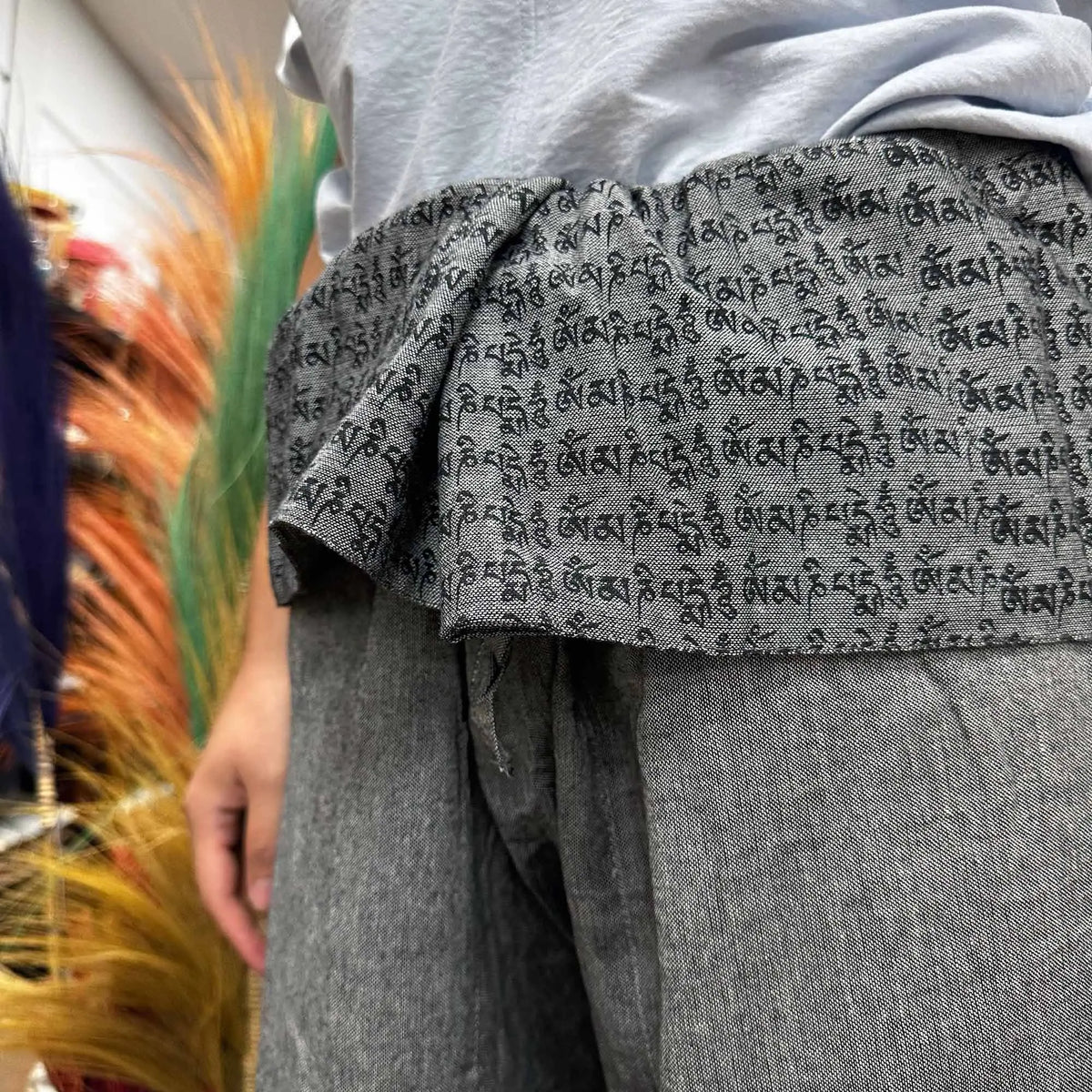 Pantalones de pescador tailandés grises con estampado de mantras negros, estilo holgado y cintura plegable.