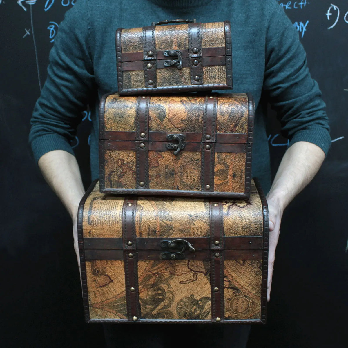 Juego de tres cofres decorativos con estampado de mapa antiguo, detalles en cuero marrón y cierres metálicos vintage.