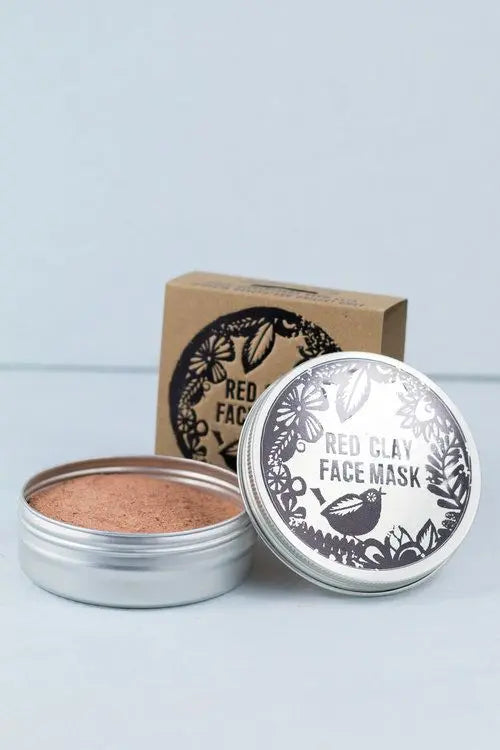 Mascarilla de arcilla roja Agnes + Cat en lata de aluminio abierta junto a caja de cartón decorada con motivos florales.