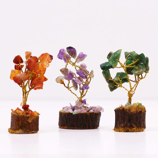 Tres mini árboles de piedras preciosas (naranja, morado y verde) con ramas de alambre dorado sobre base de madera.