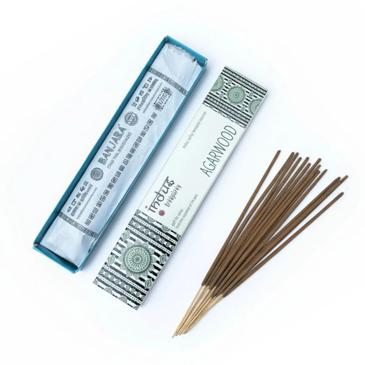 Varillas de incienso de madera de agar junto a su caja rectangular decorada con motivos geométricos y florales.