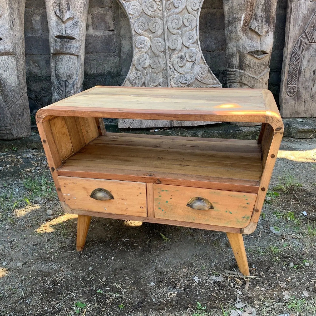Soporte para TV de madera reciclada con dos cajones, estante abierto, diseño curvo y tiradores de metal antiguos.