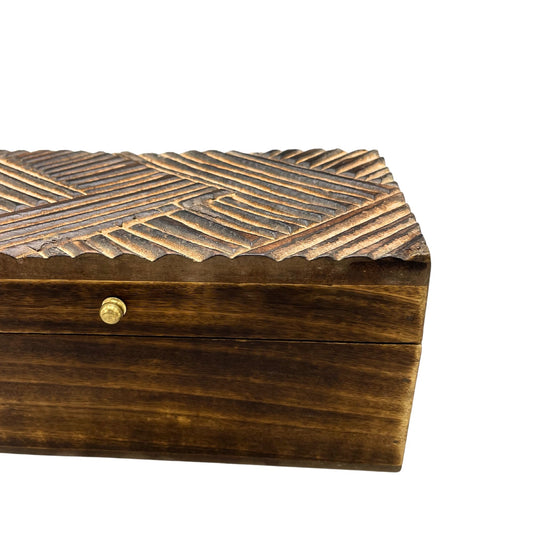 Caja de madera tallada en marrón oscuro con acabado texturizado y detalle en dorado. Ideal para almacenamiento.