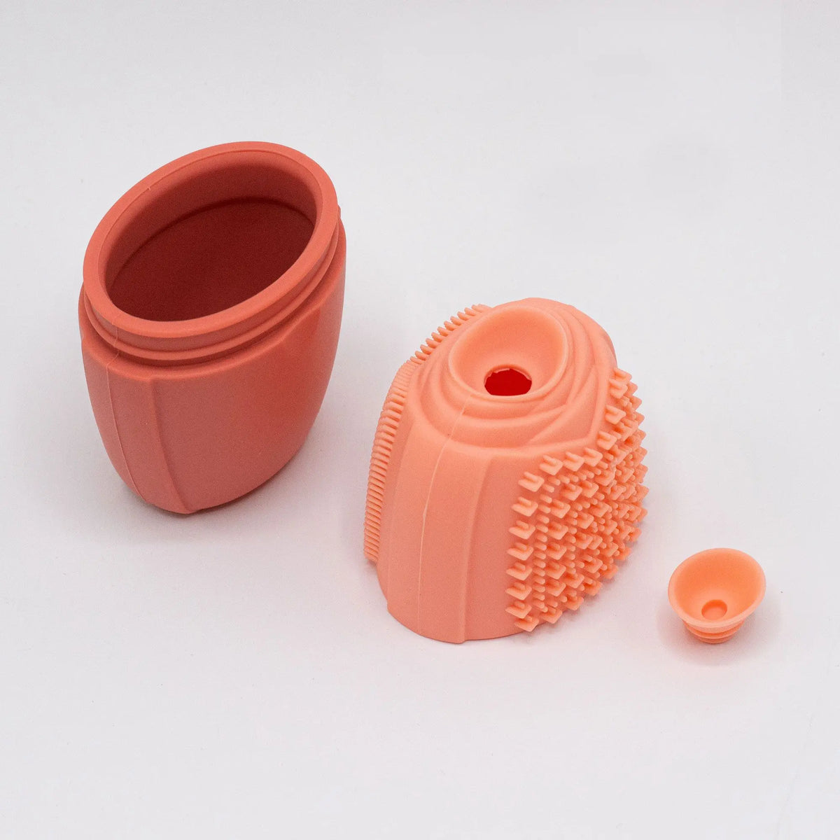 Molde de silicona color melocotón para hielo facial, compuesto por cuerpo, tapa texturizada y tapón pequeño.