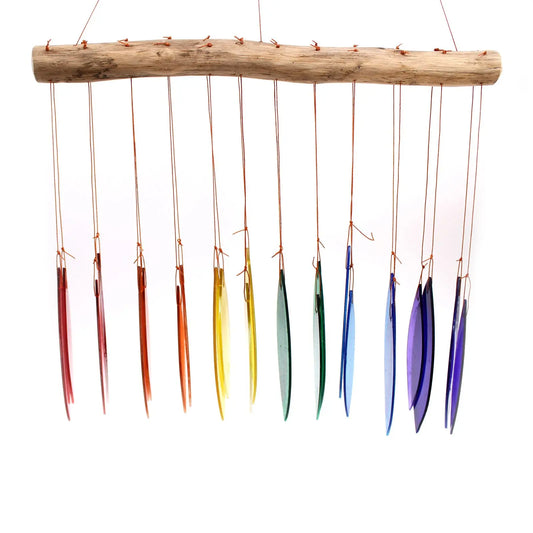 Carillón de piezas de vidrio reciclado con colores de arcoíris colgando de una rama de madera natural.