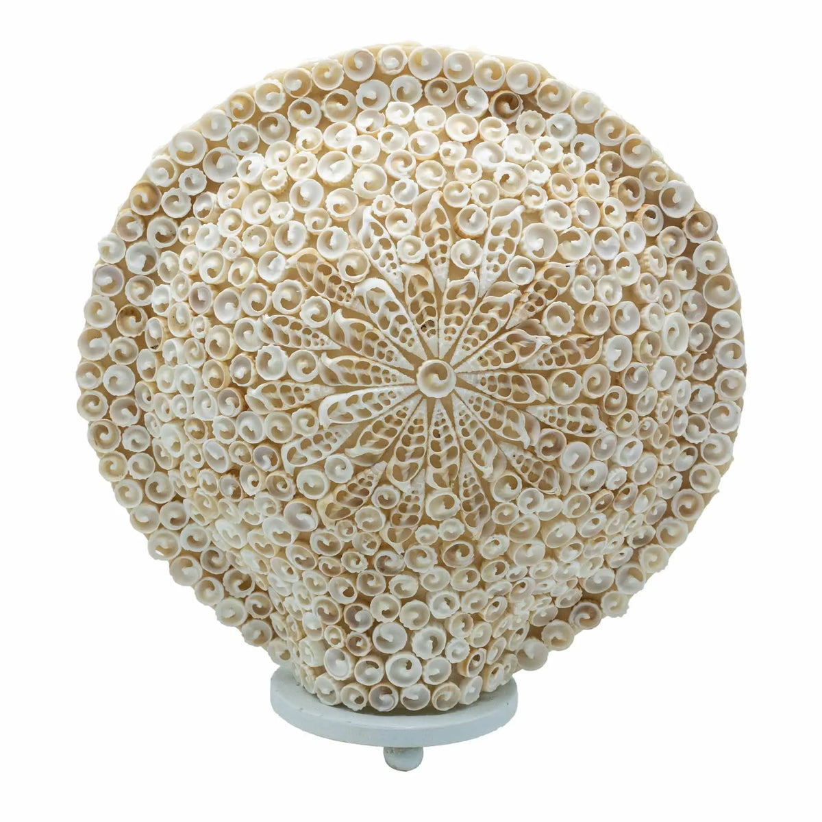 Lámpara redonda estilo boho hecha de pequeñas conchas blancas dispuestas en un patrón floral detallado sobre una base.