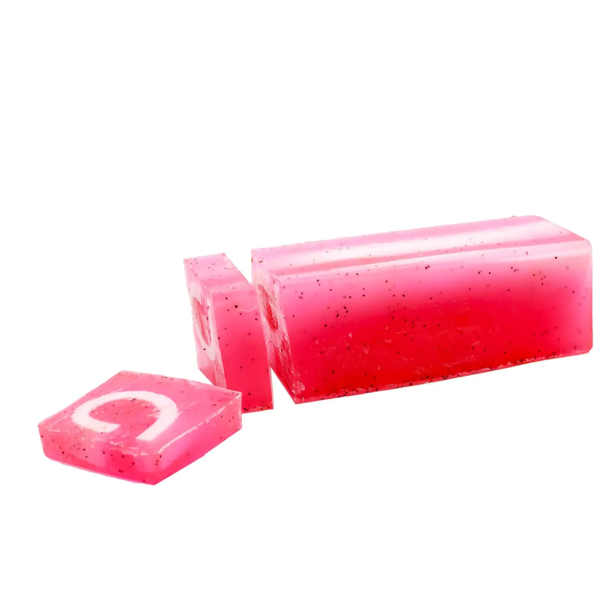 Jabón artesanal rosado translúcido con motas negras, forma rectangular, una rodaja cortada y detalle en blanco.