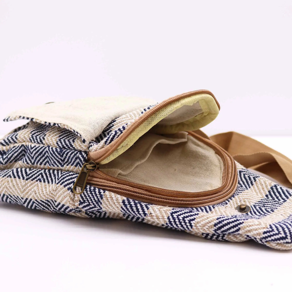 Bolso bandolera de algodón con tejido de espiga en azul marino y beige, cierre de cremallera y solapa con botón.
