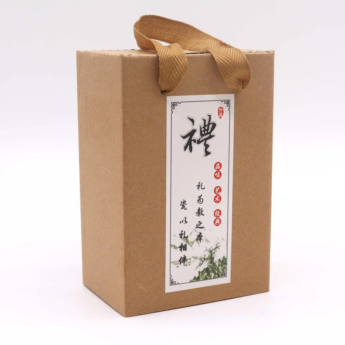 Caja de regalo de cartón para set de té, color marrón, con asa de tela y etiqueta decorativa con caligrafía oriental.