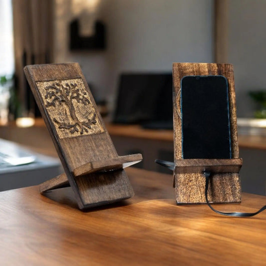 Dos soportes de madera natural con tallado artesanal de mandala sobre una mesa, uno de ellos sostiene un teléfono móvil