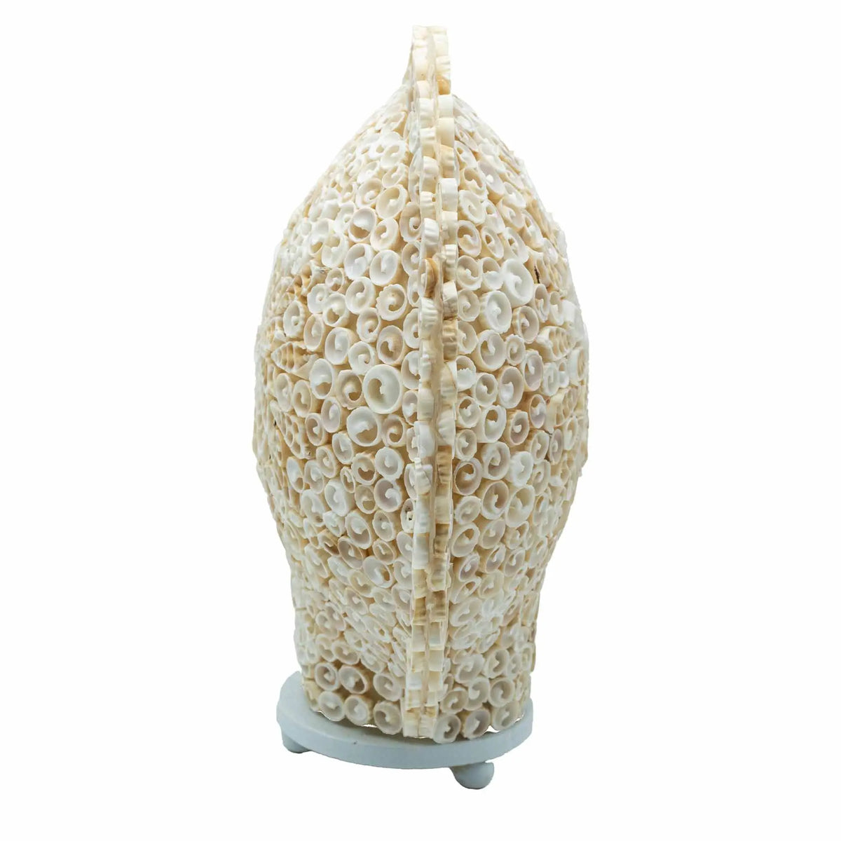 Lámpara decorativa ovalada hecha a mano con pequeñas conchas marinas blancas sobre una base circular. Estilo boho.