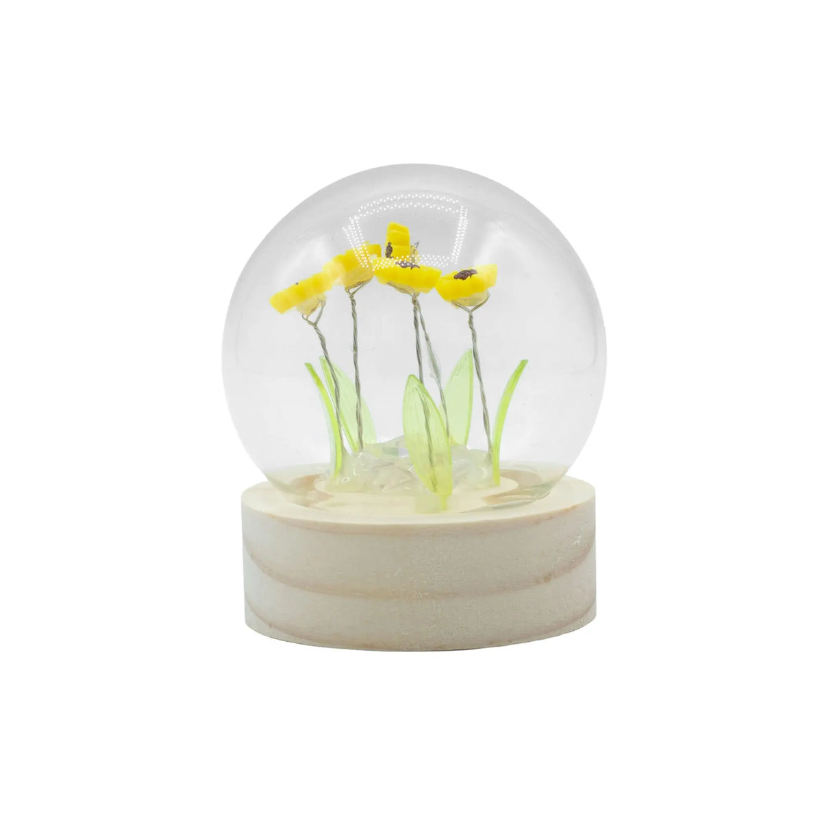 Domo de cristal con 5 girasoles amarillos, hojas verdes y luces LED sobre base de madera clara. Ancient Wisdom.