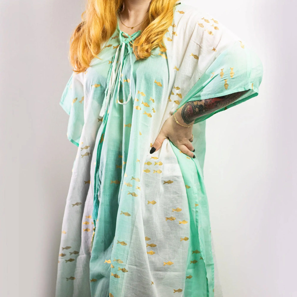 Kaftán blanco y turquesa con estampado de peces dorados, de corte amplio y cuello con lazada, estilo veraniego.