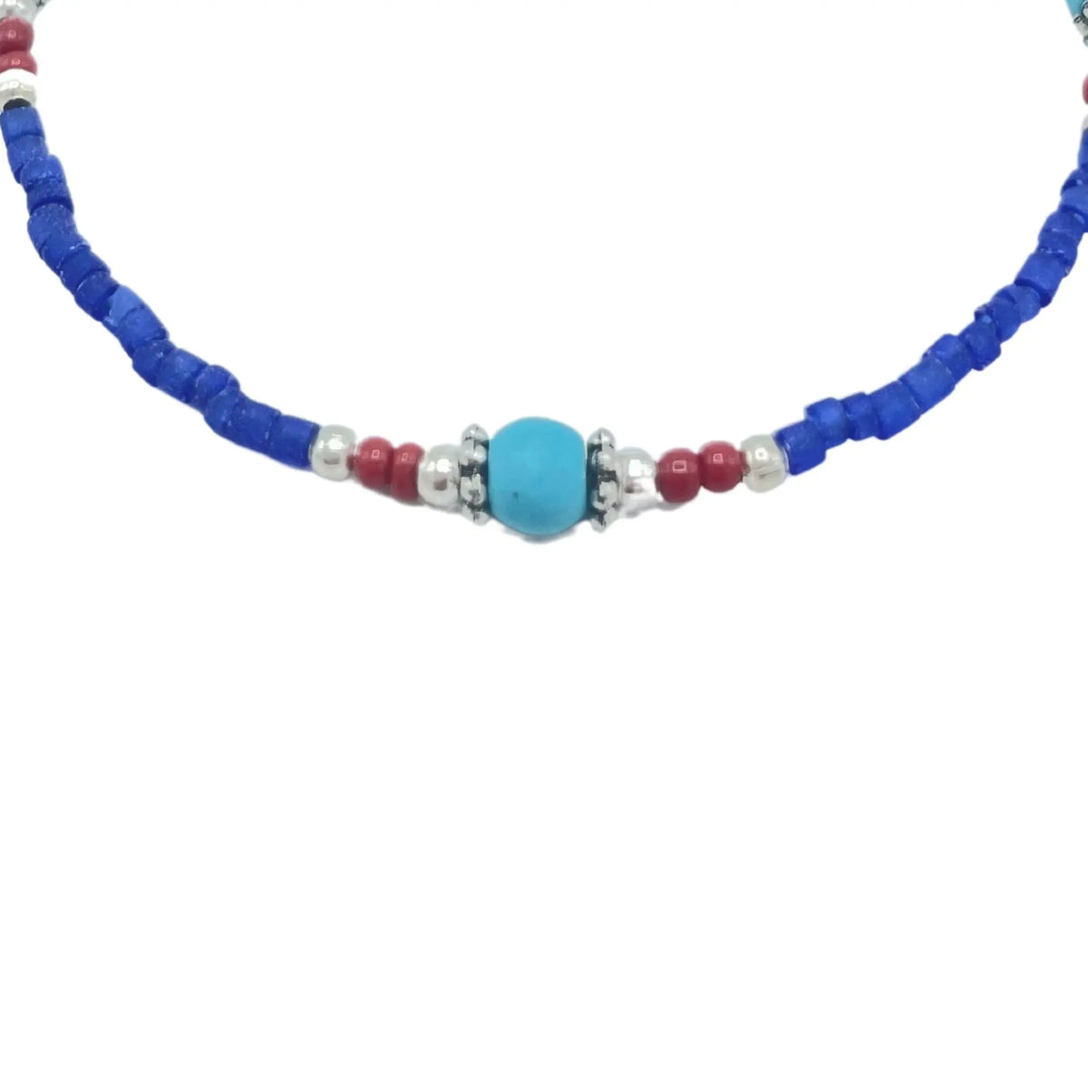 Collar hecho a mano con cuentas azules, rojas y plateadas, estilo bohemio y colorido.