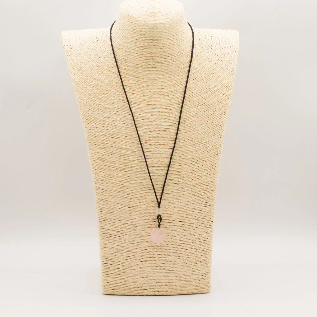 Collar de piedra rosa en forma de corazón con cordón negro, estilo bohemio y elegante.